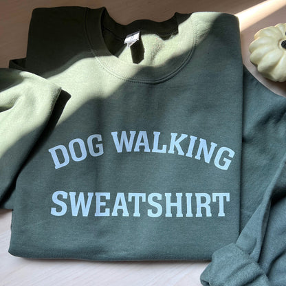 Front view of unisex army green Dog Walking Sweatshirt with white text.