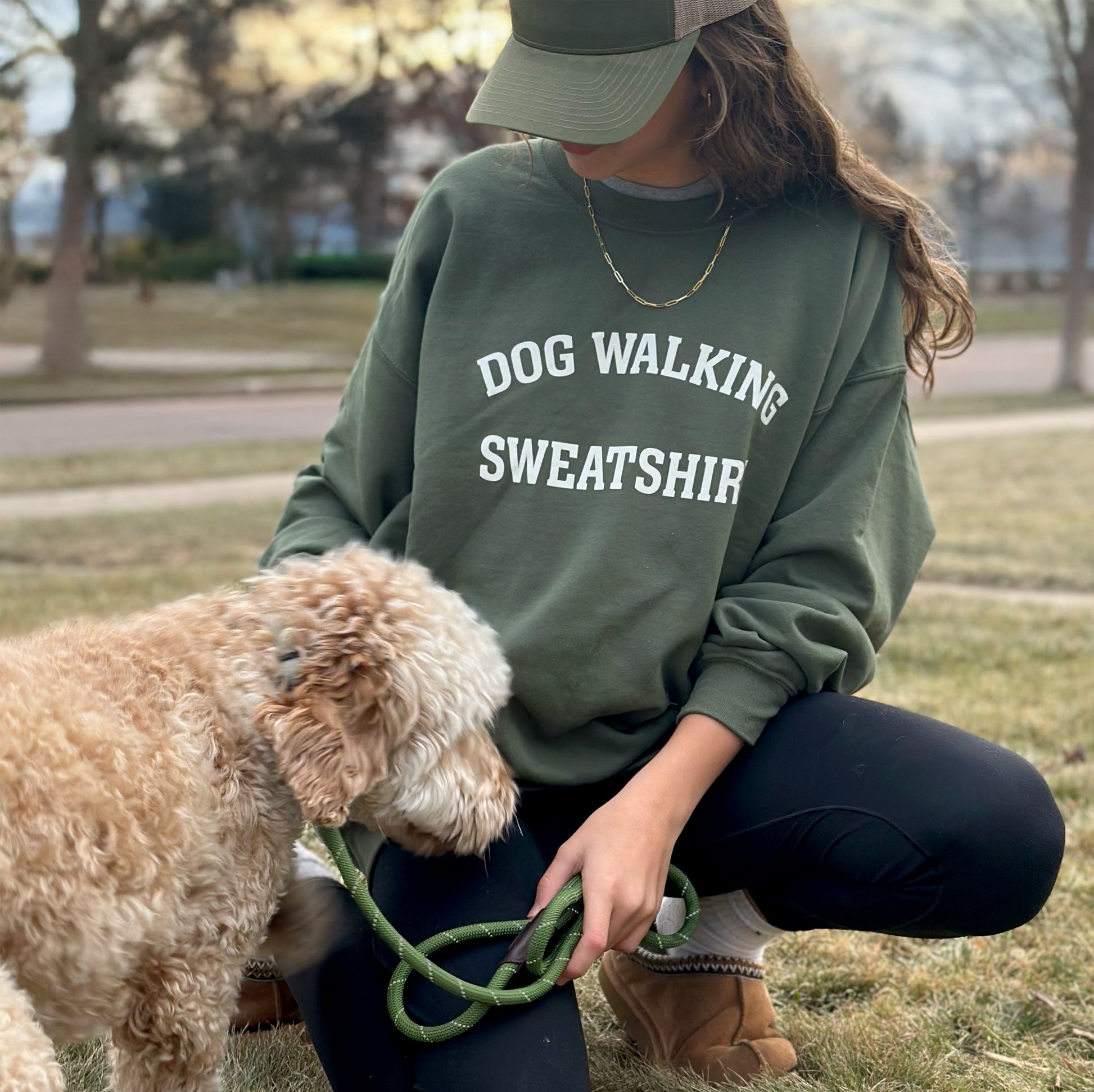Front view of unisex army green Dog Walking Sweatshirt with white text.
