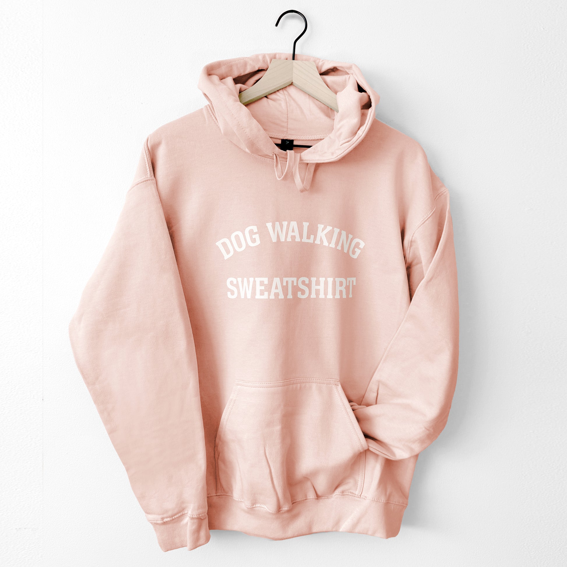 Pink hoodie with 'DOG WALKING SWEATSHIRT' text on a white background