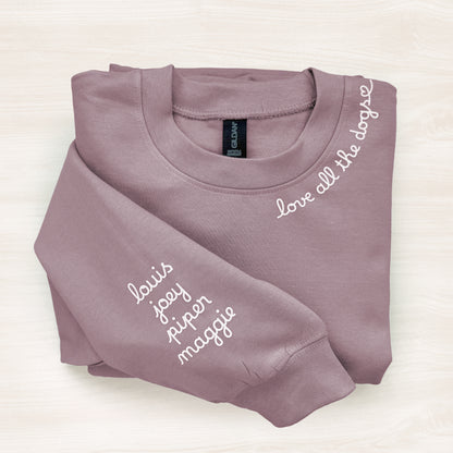 Folded mauve sweatshirt with names printed on a white background