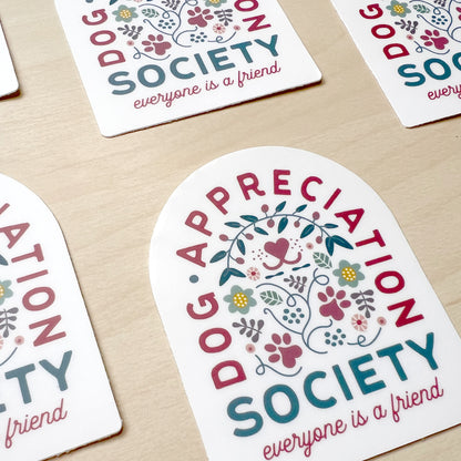 Front view of Dog Appreciation Society Sticker with dog nose, paws, flower, leaves, and hearts design.