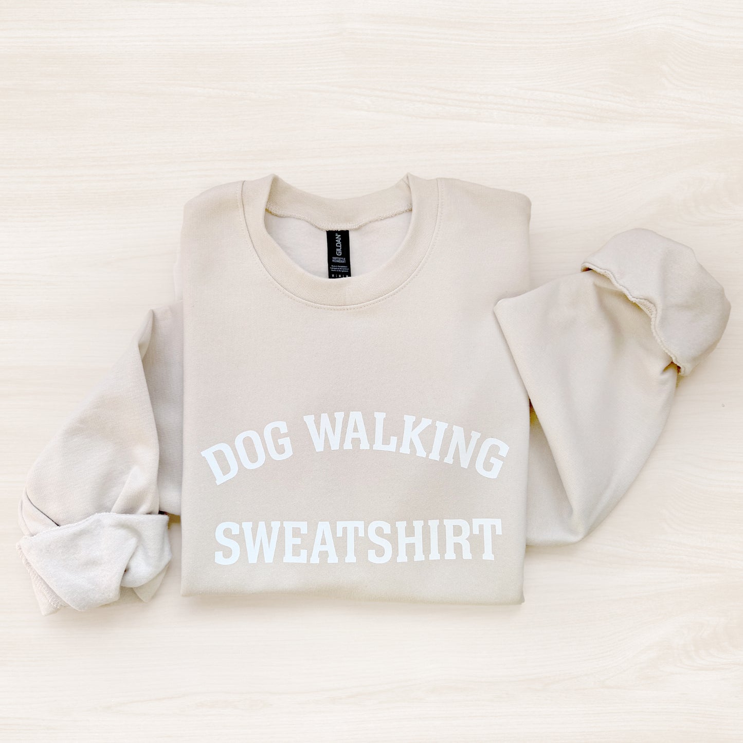 Beige sweatshirt with 'DOG WALKING SWEATSHIRT' text on a light beige background