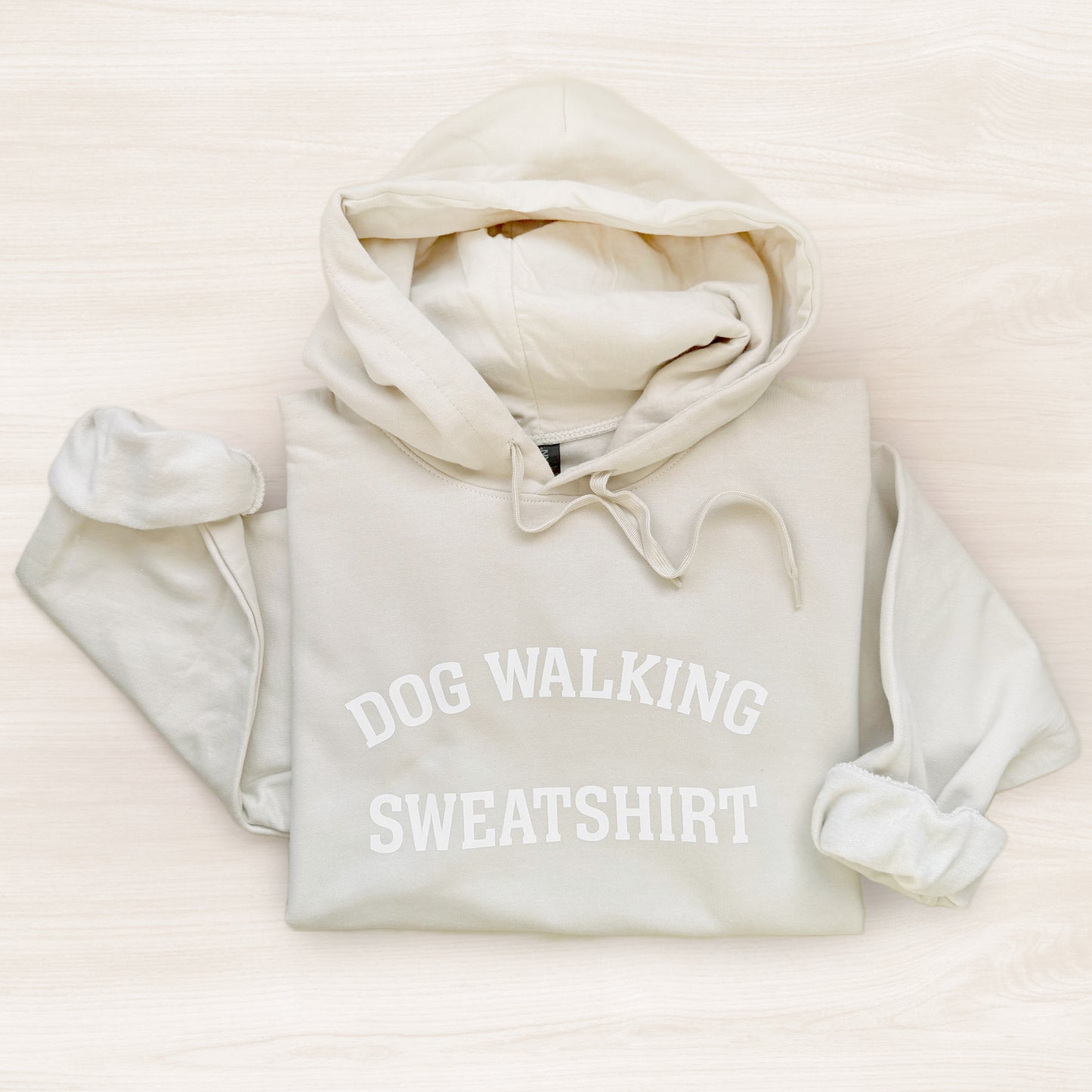 White hoodie with 'DOG WALKING SWEATSHIRT' text on a light background