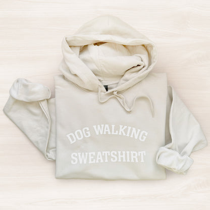 White hoodie with 'DOG WALKING SWEATSHIRT' text on a light background
